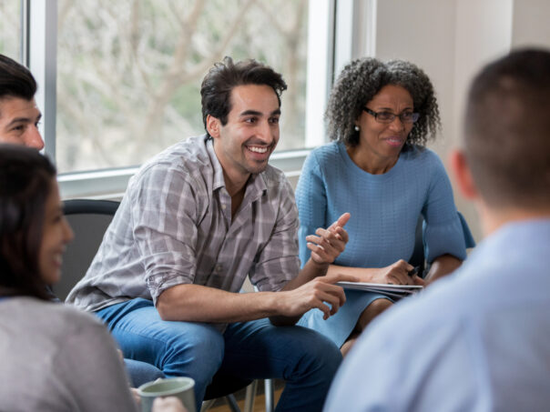 Mid adult man leads exciting business meeting